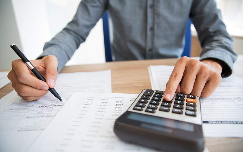 Accountant calculating financial data to ensure proper ESG assurance.