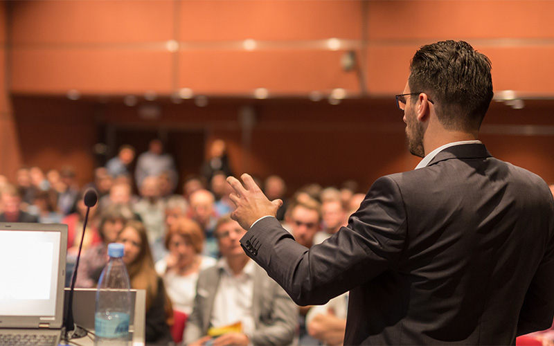 Executive presenting sustainable business practices to stakeholders at a conference.