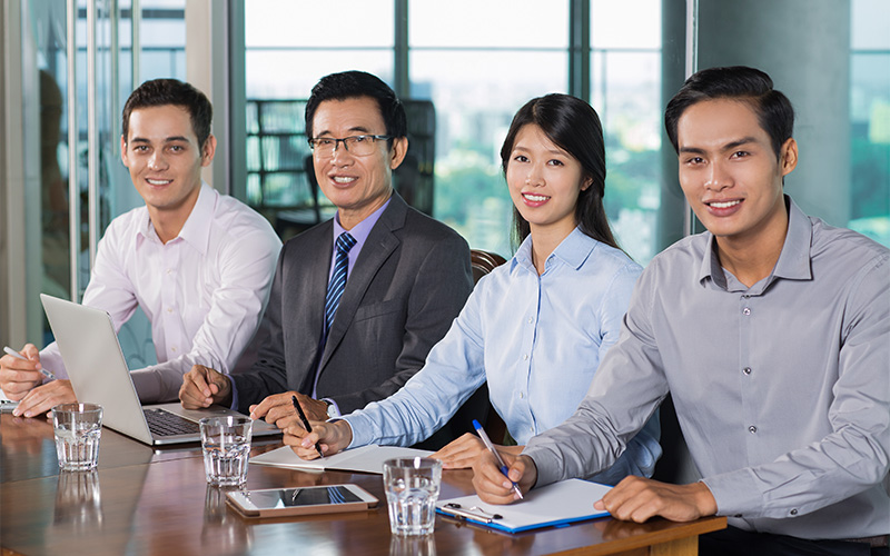 Four professionals seated at conference table.