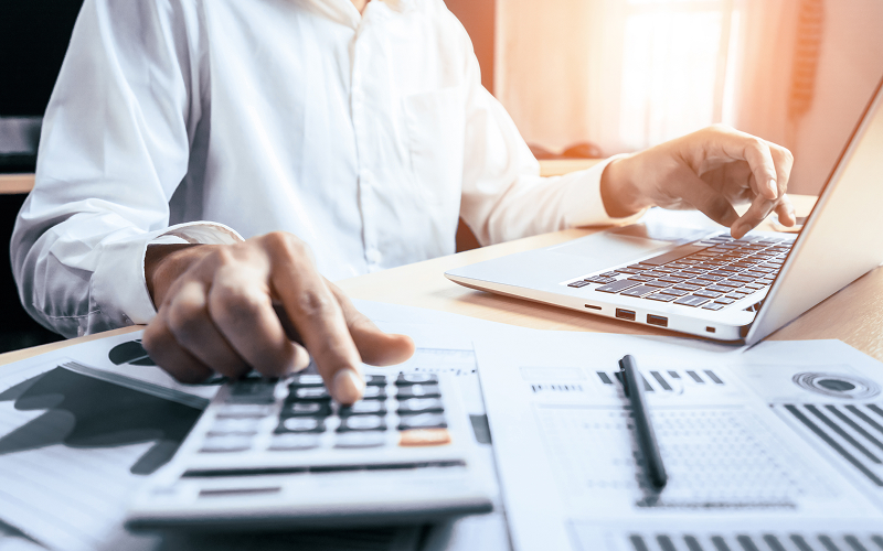 Accountant auditing financial and ESG data using a calculator.
