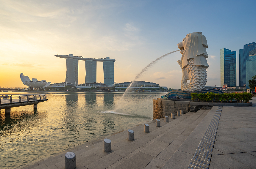 Singapore Merlion overlooking Marina Bay financial district at sunset.