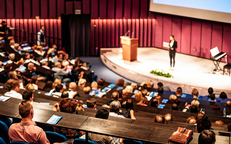 Speaker addressing a large audience at an ESG conference.