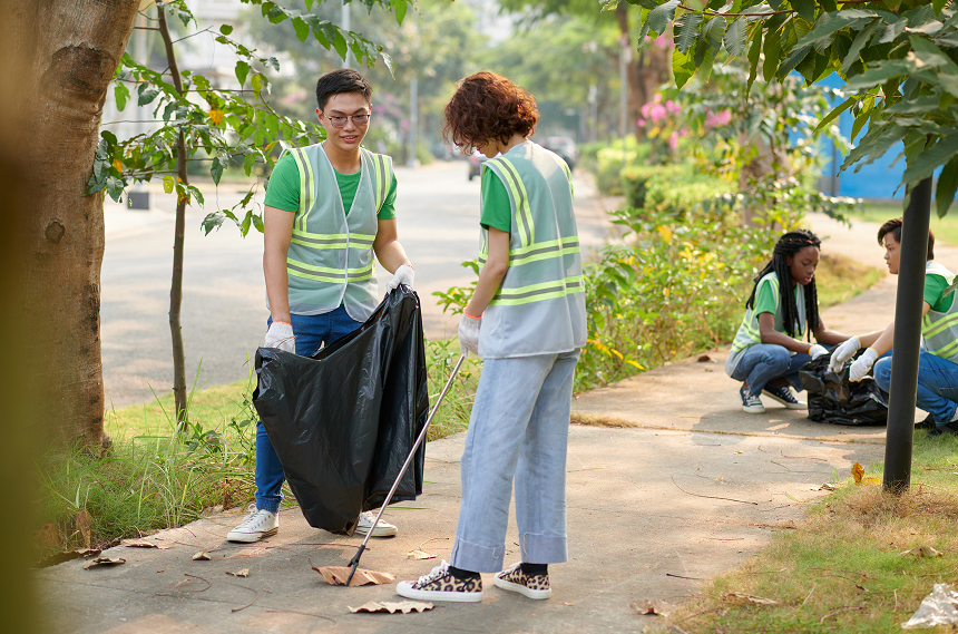 Volunteers collecting trash to support corporate environmental sustainability efforts.