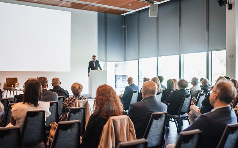 Audience listening to an ESG investment seminar presenter.