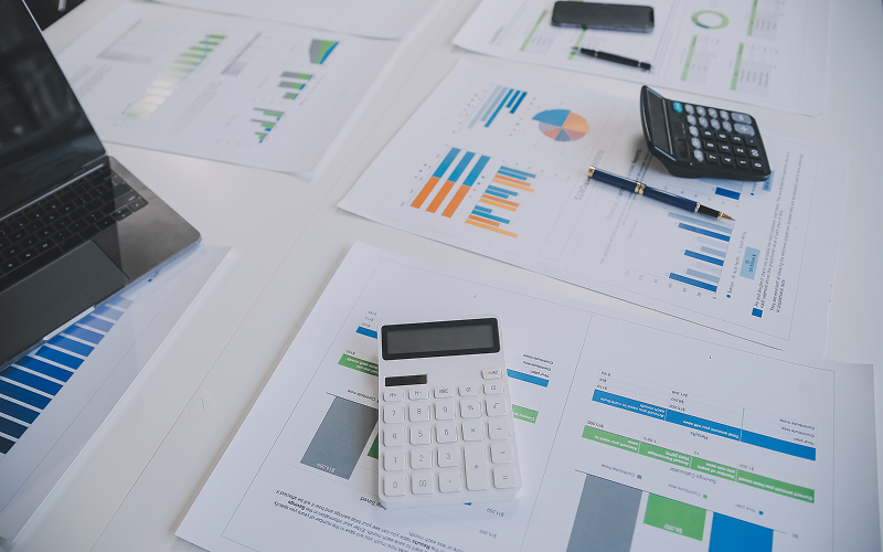 Desk with ESG financial reporting charts and calculators prepared.