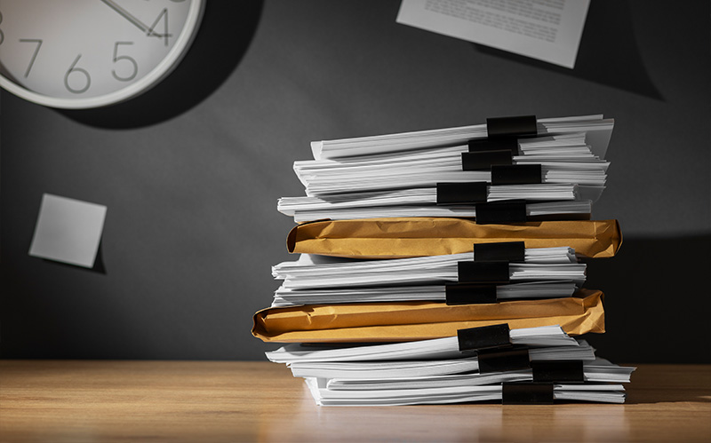 Large stack of corporate documents on a desk.