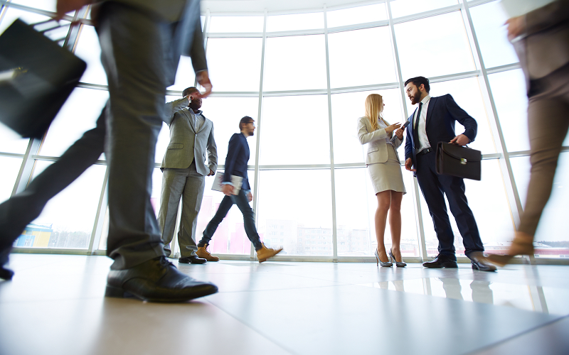 Corporate professionals walking in office, discussing business CSR strategies