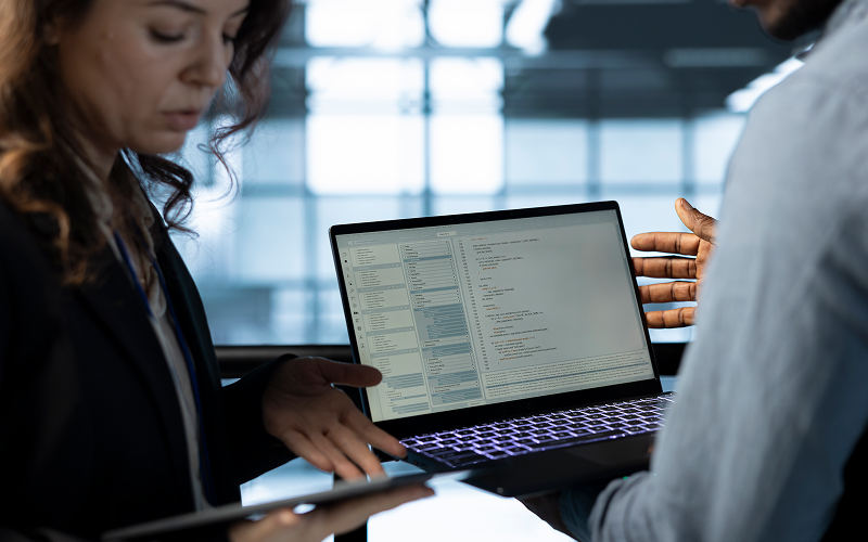 Professionals analyzing data metrics on laptop for ESG compliance